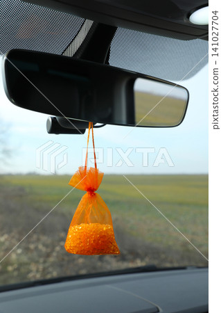 Air freshener hanging on rear view mirror in car Air freshener hanging on rear view mirror in car 141027704
