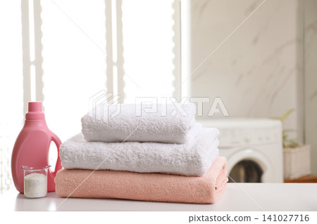 Clean towels and detergents on table in laundry room Clean towels and detergents on table in laundry room 141027716