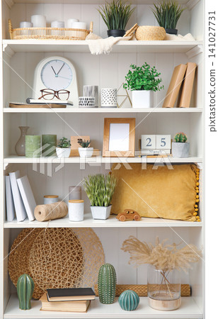 White shelving unit with plants and different decorative stuff White shelving unit with plants and different decorative stuff 141027731