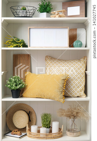 White shelving unit with plants and different decorative stuff 141027745