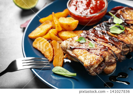 Delicious grilled ribs served on table, closeup Delicious grilled ribs served on table, closeup 141027836
