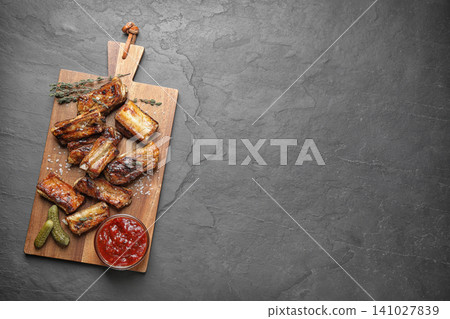 Delicious grilled ribs served on grey table, top view. Space for text Delicious grilled ribs served on grey table, top view. Space for text 141027839