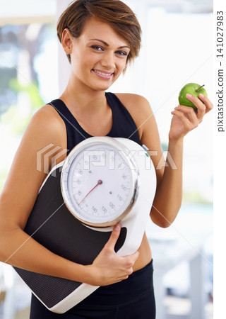Portrait, scale and happy woman with apple for fitness, nutrition or wellness with healthy body. Weight loss, smile and person with green fruit, vitamin c and eating organic food for diet outdoor Portrait, scale and happy woman with apple for fitness, nutrition or wellness with healthy body. Weight loss, smile and person with green fruit, vitamin c and eating organic food for diet outdoor 141027983