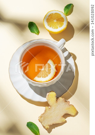 A cup of hot tea with fresh lemon, ginger, mint on a bright yellow background A cup of hot tea with fresh lemon, ginger, mint on a bright yellow background 141028092