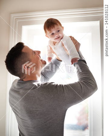 Father, baby and fun in a new home with smile and relax of a newborn with dad together. Love, support and care in a family house with development, bonding and happy with trust and proud of kid Father, baby and fun in a new home with smile and relax of a newborn with dad together. Love, support and care in a family house with development, bonding and happy with trust and proud of kid 141028112