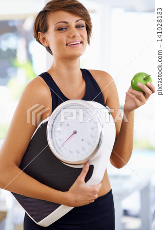 Portrait, scale and happy woman with apple for diet, nutrition or wellness with healthy body. Weight loss, smile and person with green fruit, vitamin c and eating organic food for fitness outdoor Portrait, scale and happy woman with apple for diet, nutrition or wellness with healthy body. Weight loss, smile and person with green fruit, vitamin c and eating organic food for fitness outdoor 141028183