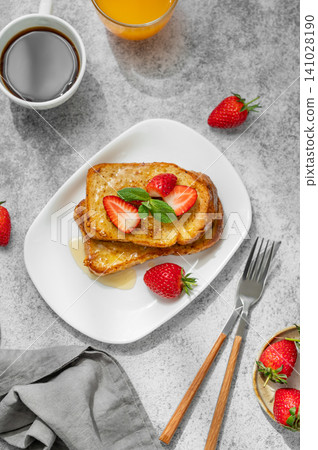 Brioche toasts with strawberry and honey on a plate on a concrete background Brioche toasts with strawberry and honey on a plate on a concrete background 141028190