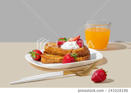 Brioche toasts with strawberries and whipped cream, drizzled with honey on a plate Brioche toasts with strawberries and whipped cream, drizzled with honey on a plate 141028198