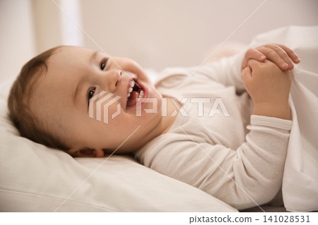 Cute little baby lying in comfortable crib. Bedtime Cute little baby lying in comfortable crib. Bedtime 141028531
