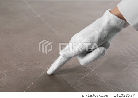 Person in white glove checking cleanliness of beige stone table, closeup Person in white glove checking cleanliness of beige stone table, closeup 141028557