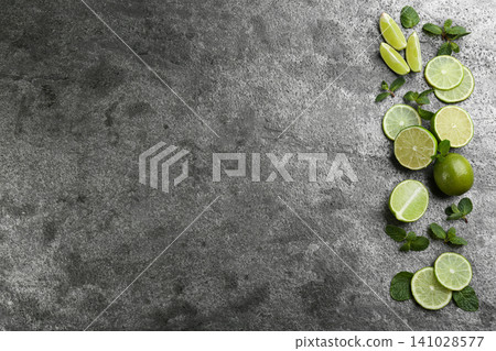 Lemonade layout with juicy lime slices and mint on grey table, top view. Space for text Lemonade layout with juicy lime slices and mint on grey table, top view. Space for text 141028577