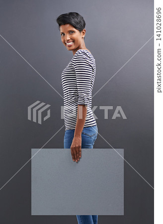 Happy woman, portrait and presentation with billboard for marketing or advertising on a gray studio background. Young female person or Indian with smile, poster or sign for message on mockup space Happy woman, portrait and presentation with billboard for marketing or advertising on a gray studio background. Young female person or Indian with smile, poster or sign for message on mockup space 141028696