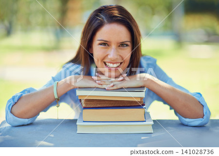 Woman, student and portrait with books for outdoor learning, education and knowledge in park or campus. Face of a happy young person with literature, university and resources for studying at a table Woman, student and portrait with books for outdoor learning, education and knowledge in park or campus. Face of a happy young person with literature, university and resources for studying at a table 141028736