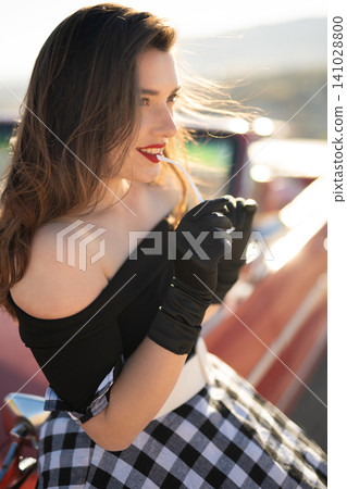 beautiful girl in retro style posing near vintage red cabriolet car. beautiful girl in retro style posing near vintage red cabriolet car. 141028800