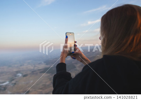 Woman filming sunrise from a hot air balloon over Pamukkale Turkey Woman filming sunrise from a hot air balloon over Pamukkale Turkey 141028821