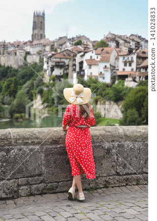 Woman in red polka dot dress overlooking Fribourg Old Town Woman in red polka dot dress overlooking Fribourg Old Town 141028833