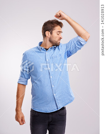 Man, smelling armpit and sweat stain, bad hygiene or body odor with stink isolated on white background. Hyperhidrosis, poor hygiene and dirty, foul or negative with disgust for underarm in studio Man, smelling armpit and sweat stain, bad hygiene or body odor with stink isolated on white background. Hyperhidrosis, poor hygiene and dirty, foul or negative with disgust for underarm in studio 141028913