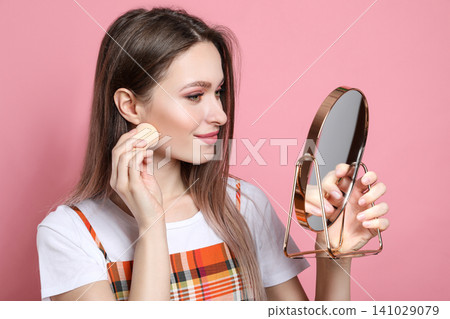 Beauty blogger doing make up on pink background Beauty blogger doing make up on pink background 141029079
