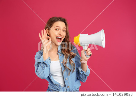 Young woman with megaphone on pink background Young woman with megaphone on pink background 141029083