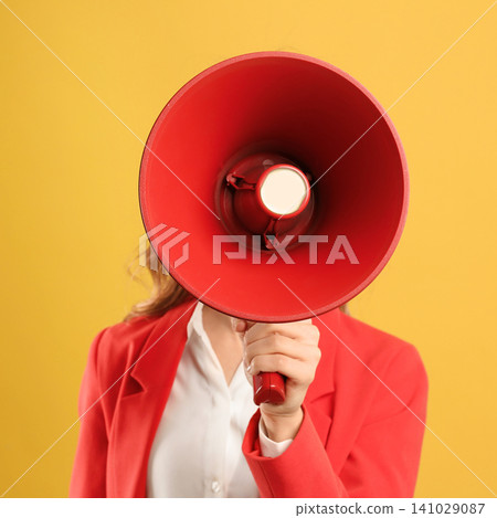 Young woman with megaphone on yellow background Young woman with megaphone on yellow background 141029087