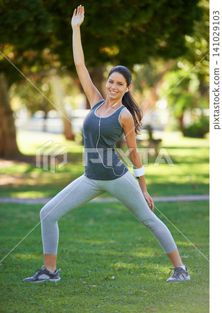 Woman, portrait and headphones with stretching in park for training, warm up and workout music. Female person, earphones and athlete in nature with balance, exercise and podcast for motivation Woman, portrait and headphones with stretching in park for training, warm up and workout music. Female person, earphones and athlete in nature with balance, exercise and podcast for motivation 141029103