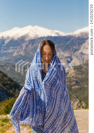 a beautiful girl on the background of the mountains is covered with a blanket a beautiful girl on the background of the mountains is covered with a blanket 141029250