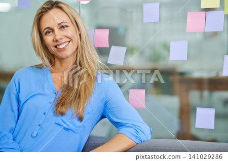 Woman, glass wall and planning with smile in portrait at startup with pride for ideas in modern office. Person, employee or worker by board for notes, paper and happy for job at creative media agency 141029286