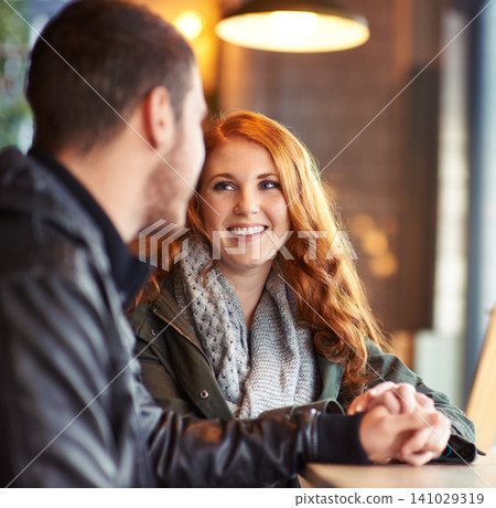 Couple, hand holding with happy smile woman, romance and affection on date. Valentines day, together with love and bonding, redhead female person in restaurant with boyfriend at table with trust Couple, hand holding with happy smile woman, romance and affection on date. Valentines day, together with love and bonding, redhead female person in restaurant with boyfriend at table with trust 141029319