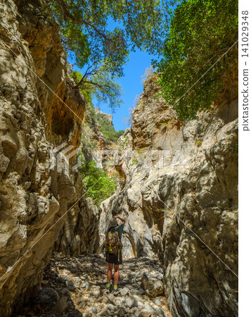 Hikers photograph in the narrow canyon of Kritsa Valley on the Greek island of Crete. Hikers photograph in the narrow canyon of Kritsa Valley on the Greek island of Crete. 141029348