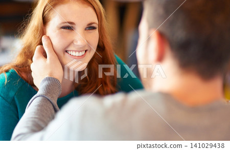 Couple, touch and woman with smile in cafe, relax and happiness for peace in relationship. Adult, female person and girl with man or partner with hand on face in coffee shop and joy in date with guy 141029438