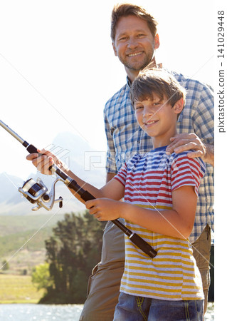 Fishing, portrait or father and son in nature for travel, bonding and vacation, holiday or trip. Fish, line or kid with dad outdoor with love, learning or sustainable living while camping in a forest 141029448