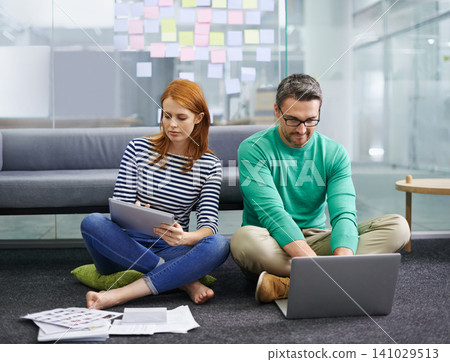 Woman, man and laptop on floor at startup with tablet, documents and thinking with teamwork in office. Business people, partnership and computer with paperwork for planning at creative media agency Woman, man and laptop on floor at startup with tablet, documents and thinking with teamwork in office. Business people, partnership and computer with paperwork for planning at creative media agency 141029513