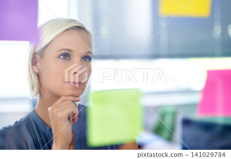 Woman, glass and wall with thinking, planning and notes with reading, proposal and ideas for development. Person, board and paper with brainstorming process, decision and choice with modern office Woman, glass and wall with thinking, planning and notes with reading, proposal and ideas for development. Person, board and paper with brainstorming process, decision and choice with modern office 141029784