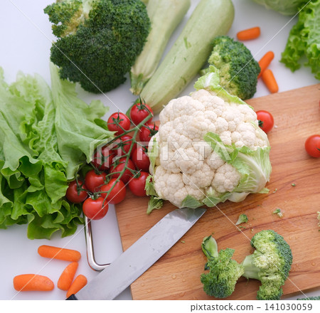 cauliflower other vegetables cutting board Chopped broccoli and other vegetables on wooden cutting board cauliflower other vegetables cutting board Chopped broccoli and other vegetables on wooden cutting board 141030059