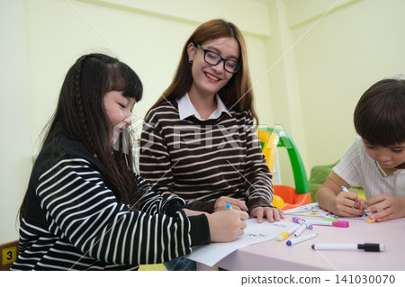 The teacher is teaching young children in a class at school. The teacher is teaching young children in a class at school. 141030070