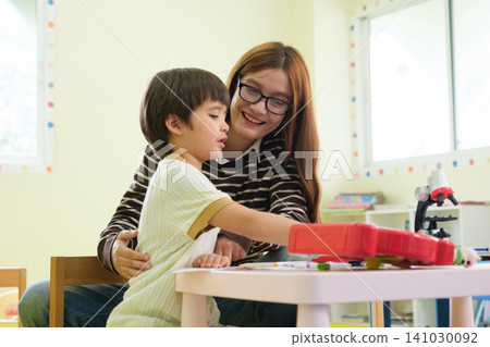 The teacher is teaching young children in a class at school. The teacher is teaching young children in a class at school. 141030092