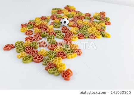 Colorful pasta pieces with football themed shapes outlining the silhouette of Germany, creating playful football themed food art. Colorful pasta pieces with football themed shapes outlining the silhouette of Germany, creating playful football themed food art. 141030500