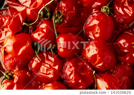 Roasted red cherry tomatoes on a black background. Roasted red cherry tomatoes on a black background. 141030620