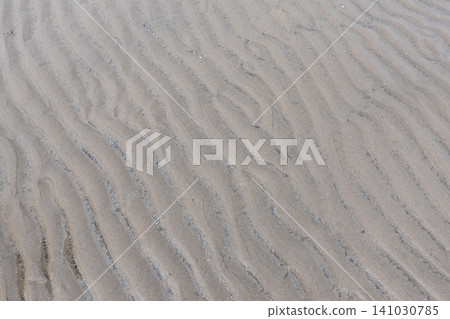 Texture of wavy sand ripple patterns formed on the beach during low tide 141030785