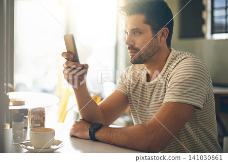 Man, relax at coffee shop with smartphone and scroll online for social media, tech and communication. Chat, reading on mobile app or ebook with break at cafe, contact and using phone with network Man, relax at coffee shop with smartphone and scroll online for social media, tech and communication. Chat, reading on mobile app or ebook with break at cafe, contact and using phone with network 141030861