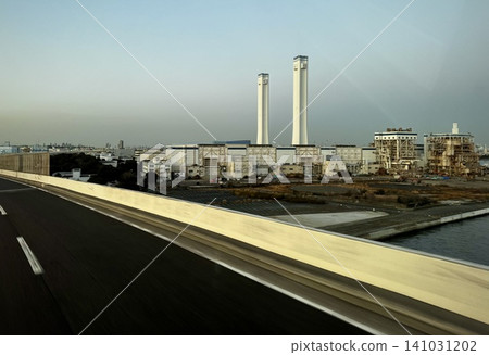 A view of the coastal industrial zone and the chimneys of a thermal power plant from the highway. A view of the coastal industrial zone and the chimneys of a thermal power plant from the highway. 141031202