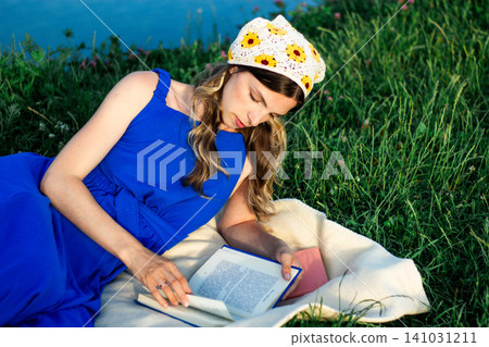 Young woman immersed in book reading. Digital detox by choice. Modern mindfulness practice outdoors on nature. Book lovers day Young woman immersed in book reading. Digital detox by choice. Modern mindfulness practice outdoors on nature. Book lovers day 141031211