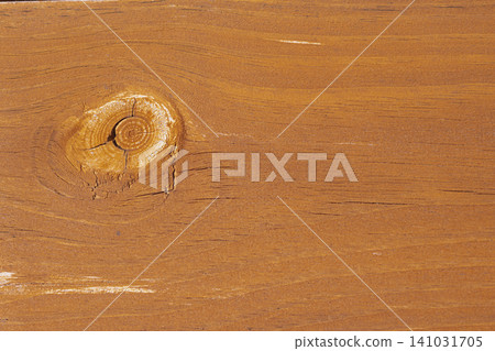 Horizontal close up top view shot of a brown varnished wooden board texture surface featuring a prominent round knot and natural parallel grain pattern lines Horizontal close up top view shot of a brown varnished wooden board texture surface featuring a prominent round knot and natural parallel grain pattern lines 141031705