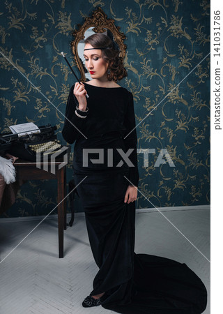 Full length portrait of 1920s style girl in black velvet dress holding a cigarette holder Full length portrait of 1920s style girl in black velvet dress holding a cigarette holder 141031786