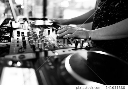 Black and white close-up of DJ hands mixing music on professional equipment 141031888