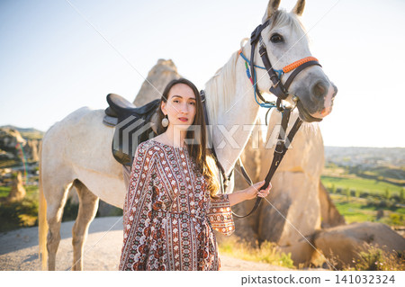 beautiful girl outdoors in the mountains with her faithful horse 141032324