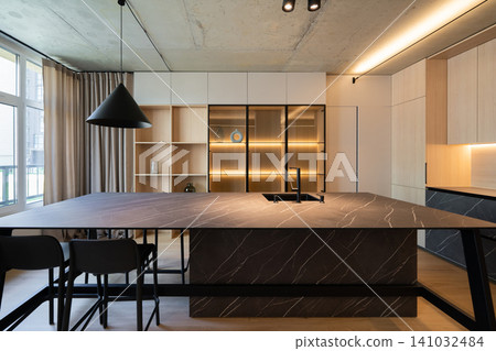 Modern kitchen interior with dark stone island and minimalist wooden cabinetry Modern kitchen interior with dark stone island and minimalist wooden cabinetry 141032484
