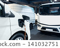 Close up of electric delivery van with connected charging cable 141032751