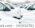 White delivery vans are parked in rows. Commercial fleet of vehicles 141032761
