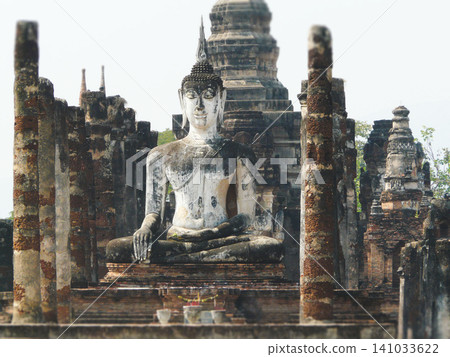 Ancient Buddha statue and ruins of Wat Mahathat in Sukhothai Historical Park Thailand Ancient Buddha statue and ruins of Wat Mahathat in Sukhothai Historical Park Thailand 141033622